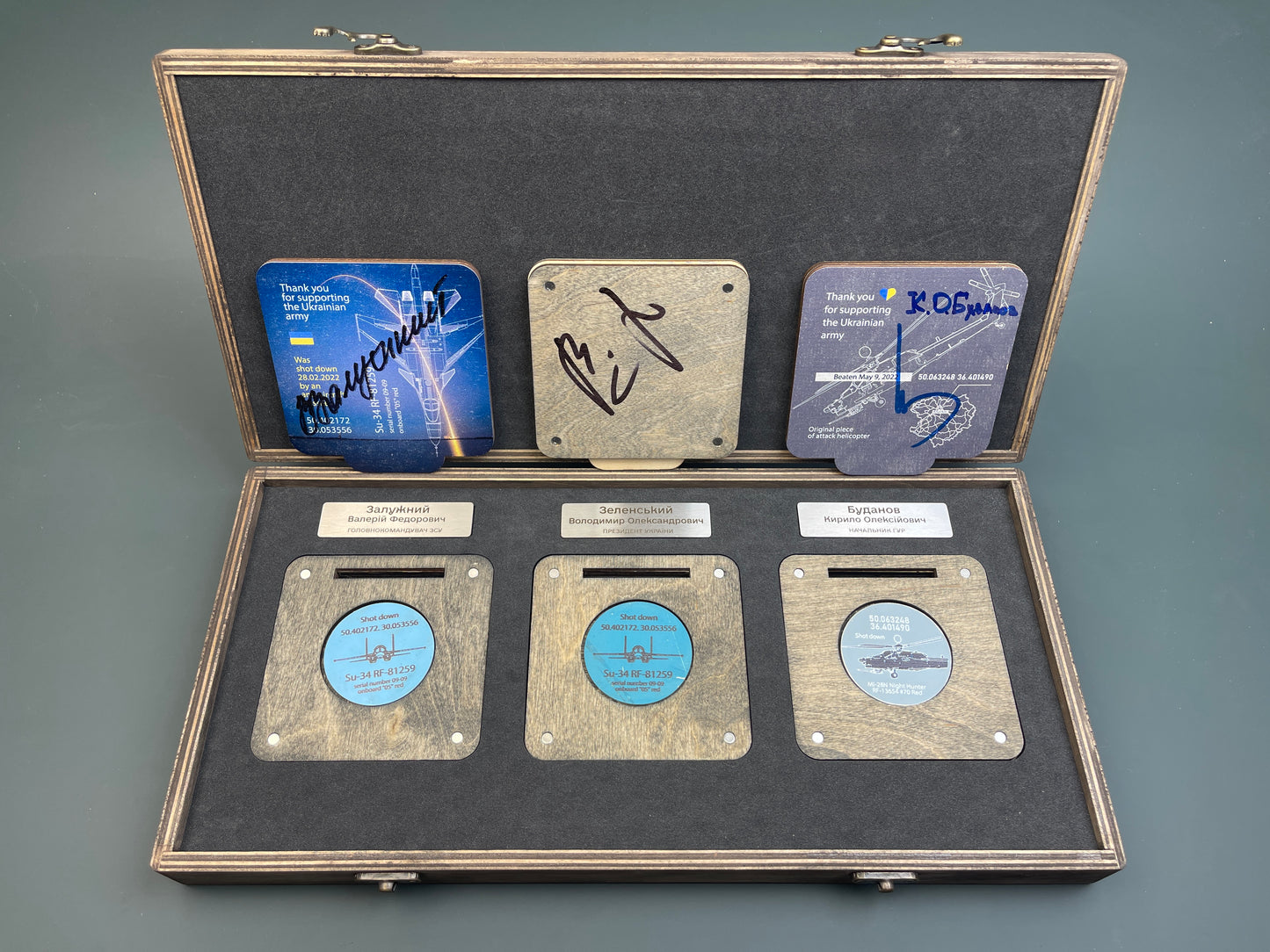 A set of coins with the autographs of President Zelensky and generals Zaluzhny and Budanov